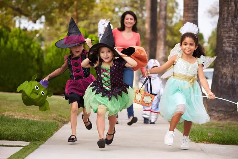 Parent Taking Children Trick Or Treating At Halloween | North Houston